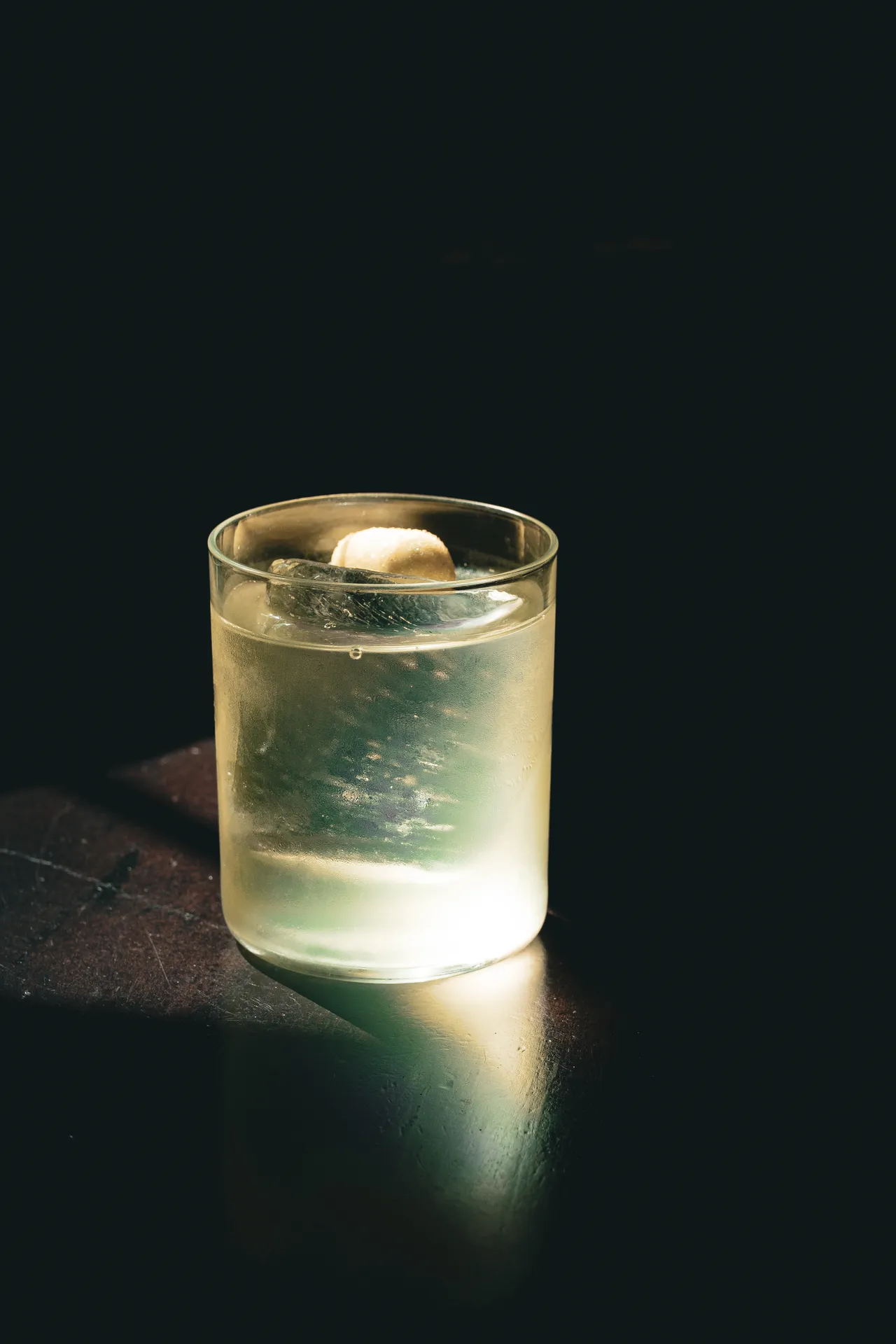Tumbler satinato con drink chiaro che emerge dal buio